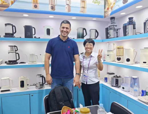 Hình ảnh các thành viên trong nhóm Zhongshan Yuekon Electrical Appliances Co., Limited và các khách hàng quốc tế mỉm cười khi chụp ảnh nhóm, phản ánh sự tương tác kinh doanh tích cực.